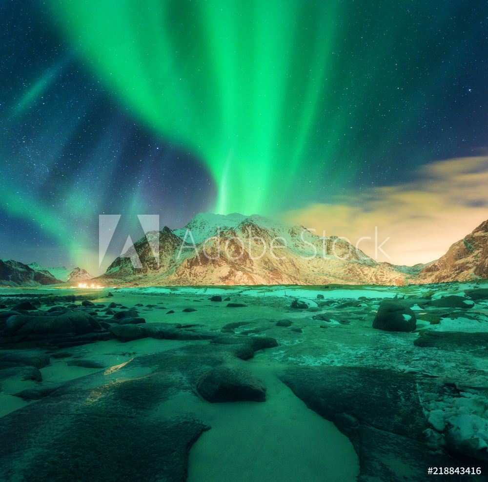 Aurora over snowy mountains Northern lights in Lofoten islands Norway  Starry sky with polar lights Night winter landscape with green aurora  borealis stones sandy beach rocks illumination valmistajalta  Valokuvatapetit | Kotitapetti