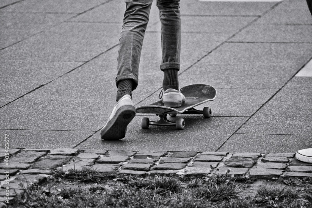 Picture of Low Section Of Man Skateboarding On Footpath