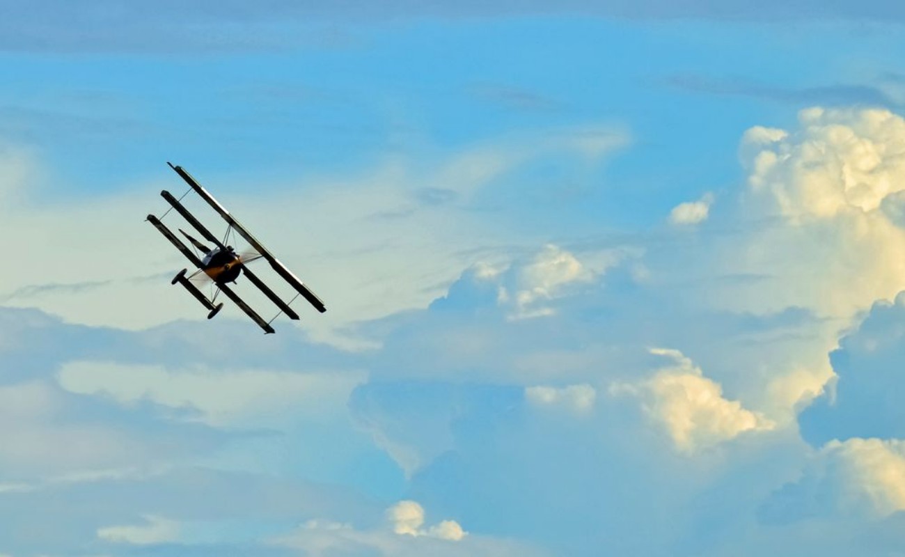 Bild på Antique Plane Flying on Blue Sky