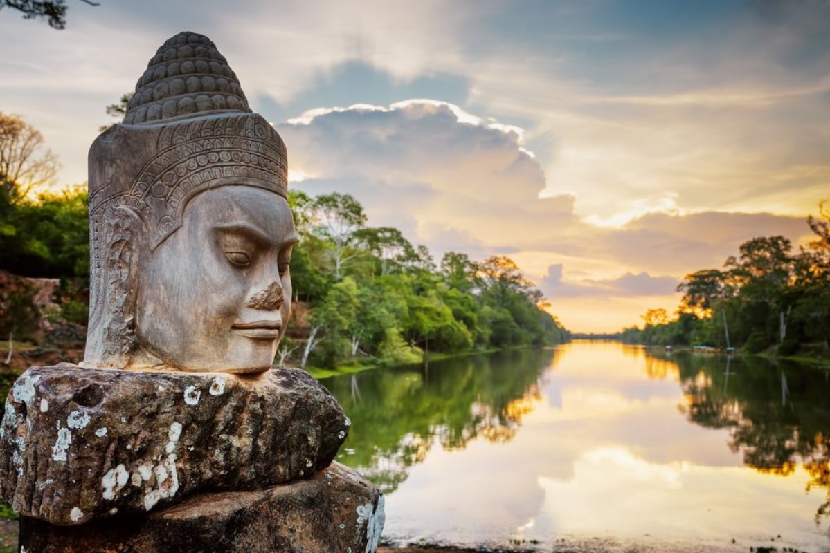 Bild på Stone face Asura and sunset over moat Angkor Thom Cambodia