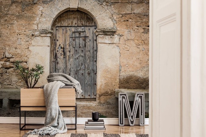 Bild på Ancient wooden door on a stone made wall and cement benches