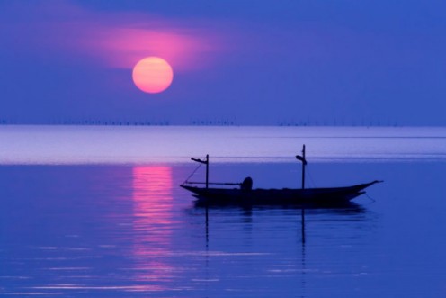 Image de Peaceful Morning at sunrise with small boat silhouette in the beach