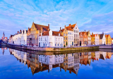 Afbeeldingen van Cityscape view of Bruges and traditional houses reflected in water at sunrise in Belgium