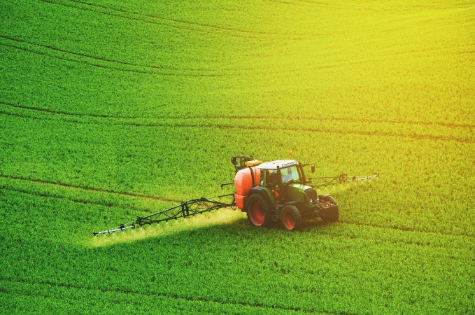 Picture of Farm machinery spraying insecticide to the green field agricultural natural seasonal spring background