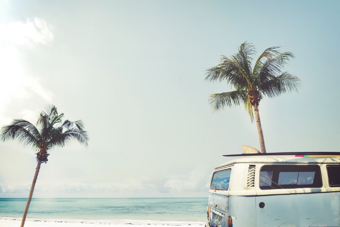 Picture of Vintage car parked on the tropical beach seaside with a surfboard on the roof - Leisure trip in the summer