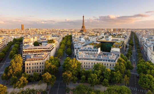 Picture of Paris from above showcasing rooftops the Eiffel Tower tree-lined avenues with haussmannian buildings lit by the setting sun Avenue Kleber Avenue dIena and Avenue Marceau 16th arrondissement