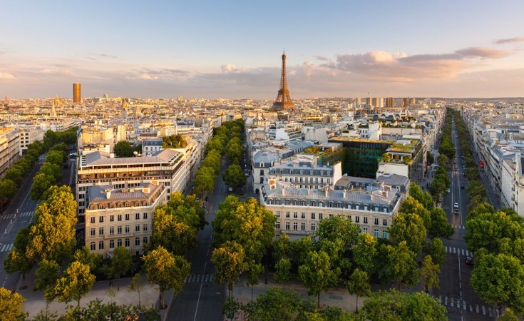 Bild på Paris from above showcasing rooftops the Eiffel Tower tree-lined avenues with haussmannian buildings lit by the setting sun Avenue Kleber Avenue dIena and Avenue Marceau 16th arrondissement