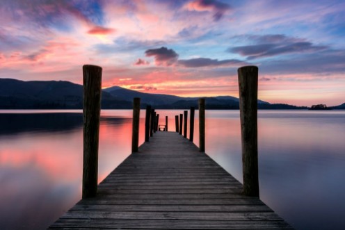 Afbeeldingen van Stunning vibrant pink and purple sunset on a beautiful evening at Ashness Jetty Derwentwater Lake District UK
