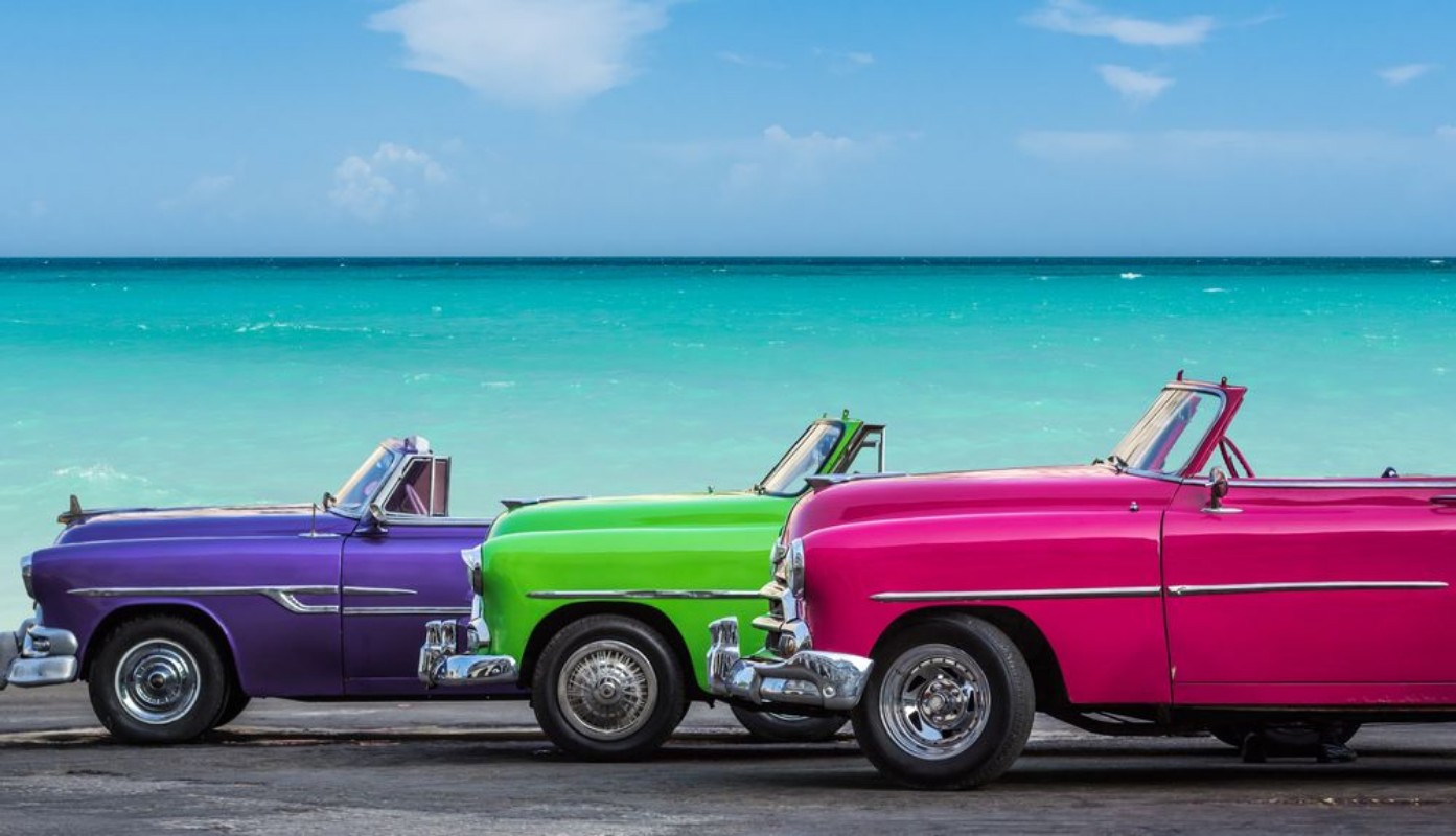Bild på Drei amerikanische Oldtimer am Strand von Havanna Kuba