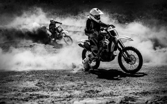 Picture of Motocross racer accelerating in dust track Black and white photo