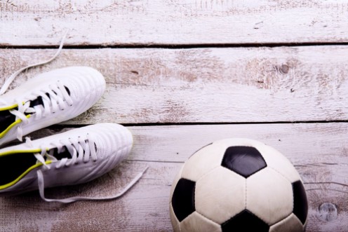 Afbeeldingen van Soccer ball cleats on white wooden floor studio shot