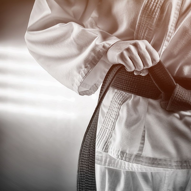 Afbeeldingen van Composite image of fighter tightening karate belt