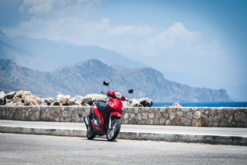 Afbeeldingen van Red motorcycle near sea coastline at Paleochora town on Crete island