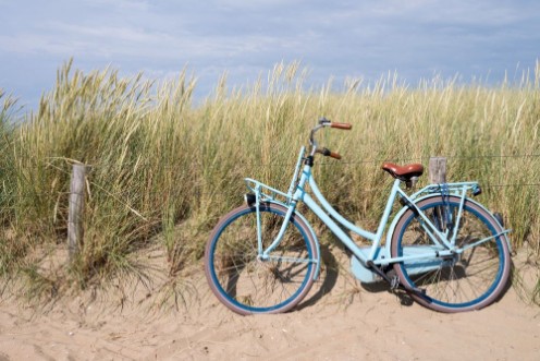 Afbeeldingen van Blaues Fahrrad abgestellt in den niederlndischen Dnen