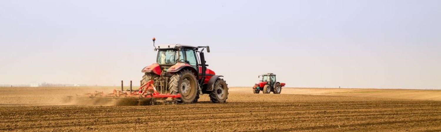 Afbeeldingen van Farmer in tractor preparing land with seedbed cultivator