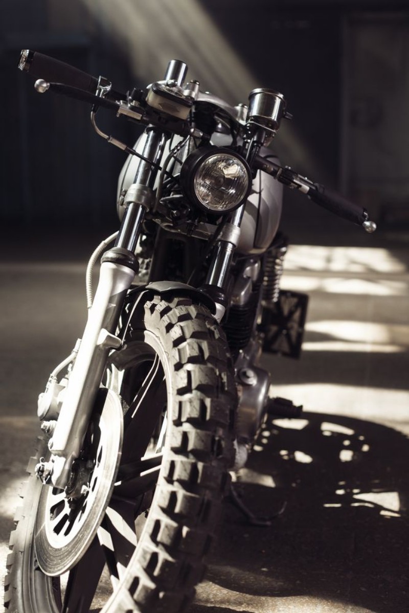 Afbeeldingen van Motorcycle standing in dark building in rays of sunlight