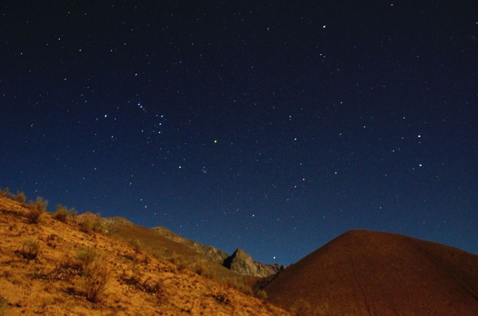 Bild på Stargazing in Elqui Valley with hundreds of stars in the sky between black hills in Chile South America