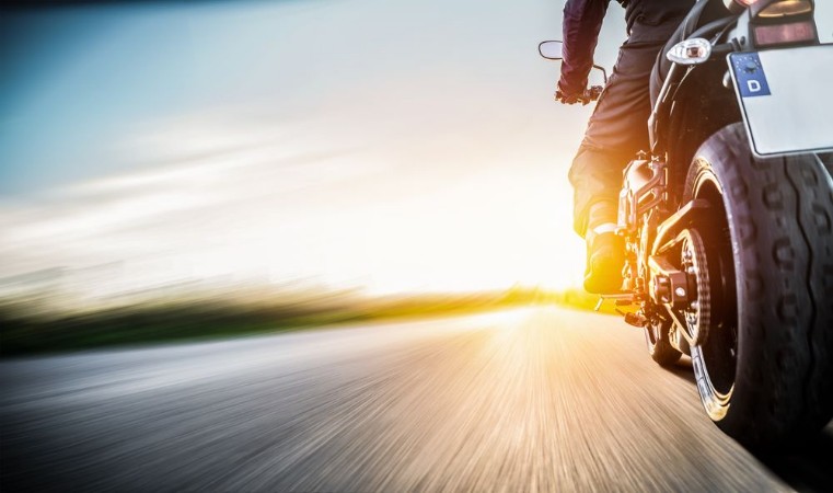 Afbeeldingen van Motorrad fhrt auf freier Landstrasse in den Sonnenuntergang
