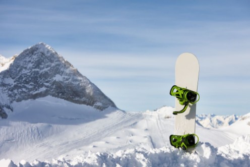 Afbeeldingen van Snowboard in snow slope on a beautiful mountain background
