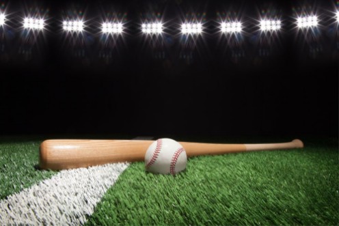 Afbeeldingen van Baseball and bat at night under stadium lights on grass field