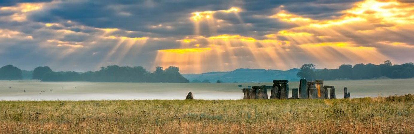 Afbeeldingen van Amesbury Wiltshire United Kingdom - August 14 2016 Cloudy sunrise over Stonehenge - prehistoric megalith monument arranged in circle