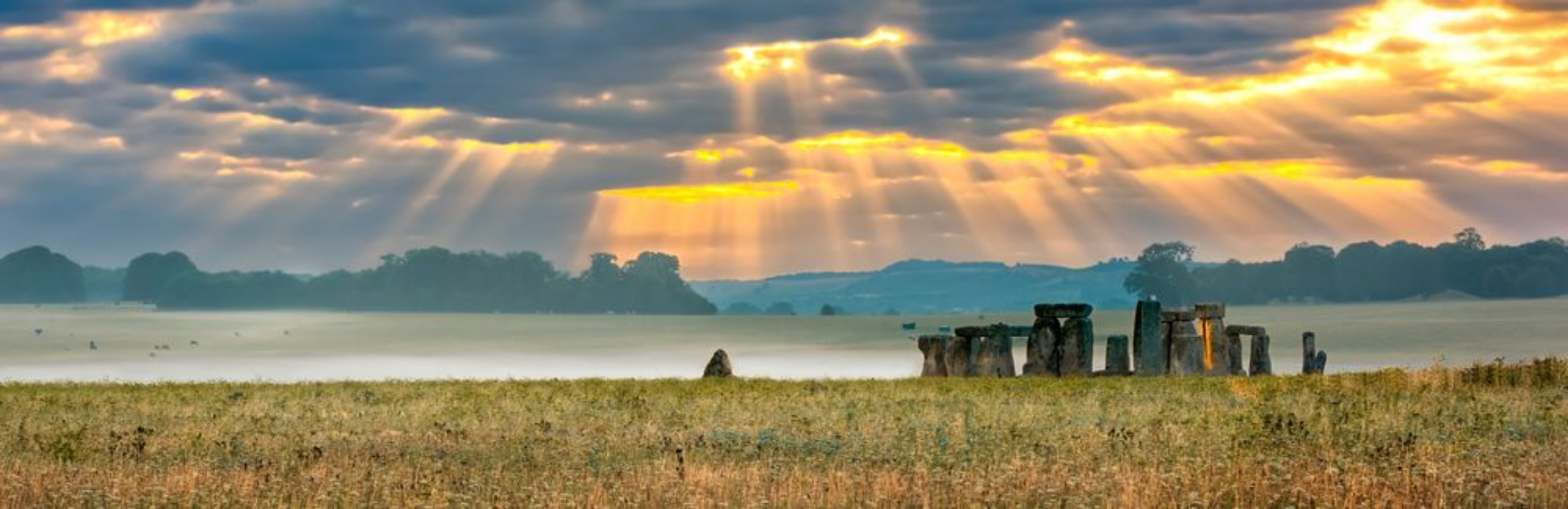 Afbeeldingen van Amesbury Wiltshire United Kingdom - August 14 2016 Cloudy sunrise over Stonehenge - prehistoric megalith monument arranged in circle