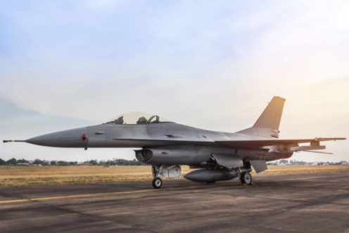 Picture of F16 falcon fighter jet military aircraft parked in the runway on sunset 