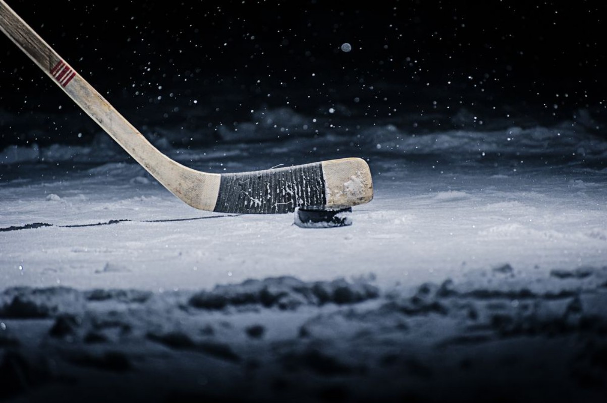 Afbeeldingen van Hockey Stick and Puck on the Ice Rink