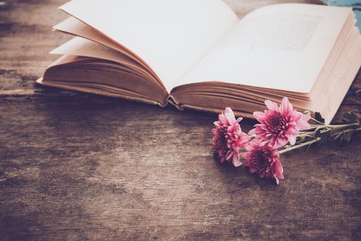 Bild på Vintage novel books with bouquet of flowers on old wood background - concept of nostalgic and remembrance in spring vintage background