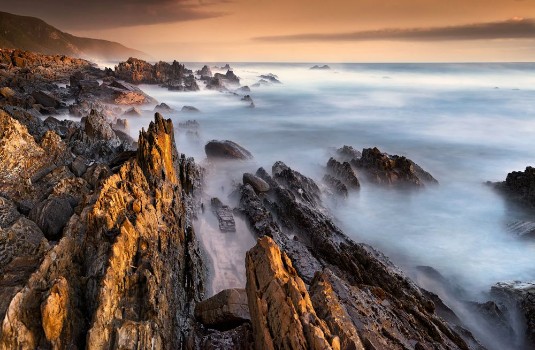 Bild på Craggy coastal rocks at Storms River South Africa