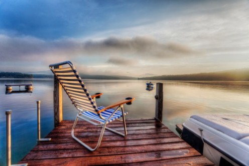 Image de Chair sitting at the end of a dock in very early morning summer light
