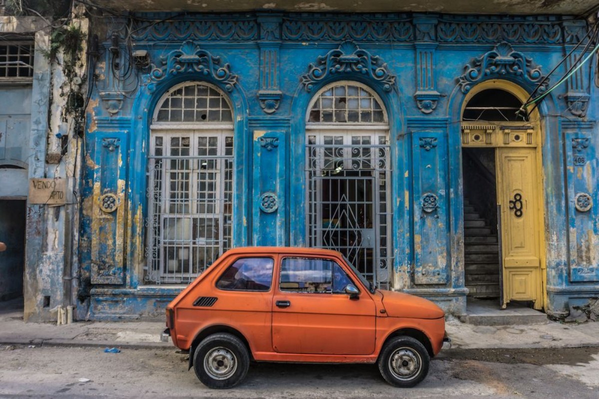 Bild på Old small car in front old blue house general travel imagery on december 26 2016 in La Havana Cuba