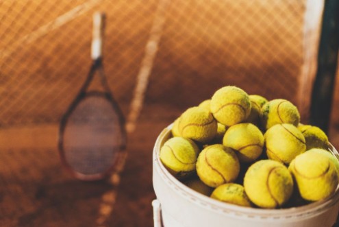 Afbeeldingen van Tennis balls at hopper tennis racket in the blurred background sportive and healthy lifestyle