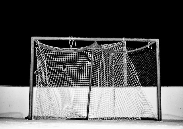 Afbeeldingen van Close-up of tattered and frayed mesh on a hockey net on an outdoor ice skating rink at night in black and white