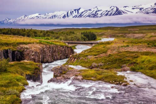 Afbeeldingen van The creek flows among the flat tundra