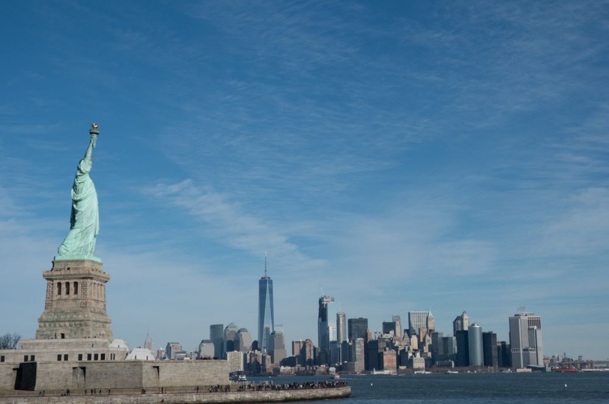 Image de Statue of Liberty in Profile with Manhattan skyline in background Bright sunny day Wall Street and Financial District of lower Manhattan in the background  View from ferry across the harbor