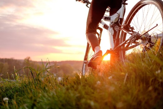 Bild på Girl riding bike in sunset