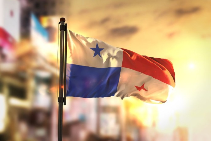 Bild på Panama Flag Against City Blurred Background At Sunrise Backlight