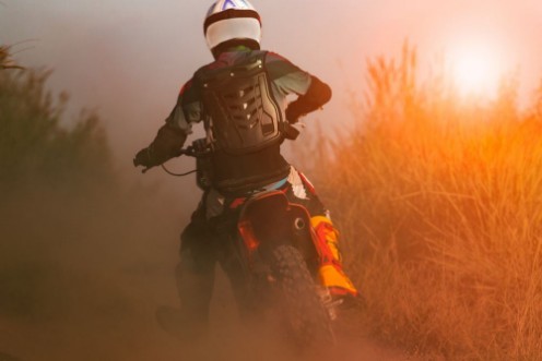 Afbeeldingen van Man riding sport enduro motorcycle on dirt track