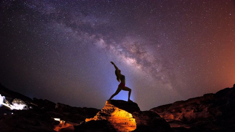 Afbeeldingen van Landscape with Milky way galaxy Night sky with stars and silhouette woman practicing yoga on the mountain