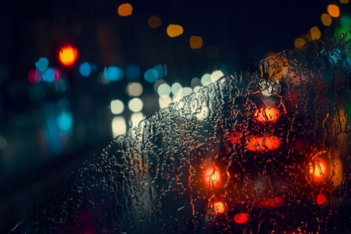 Picture of Blurry cars and lights in traffic in a rainy night seen through windscreen