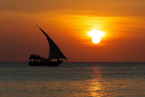 Afbeeldingen van Stunning sunset captured north on Zanzibar Tanzania Africa Sailboat passing by