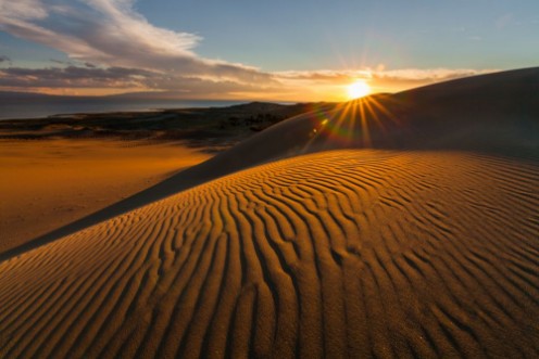 Afbeeldingen van Picturesque desert landscape with a golden sunset over the dunes