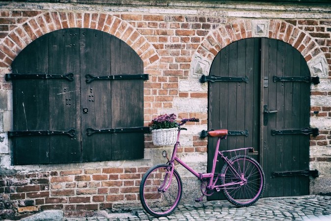 Pink bike standing by the wall photowallpaper Scandiwall