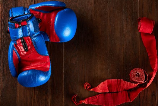 Picture of Sport background with blue and red gloves and red bandage on wooden background