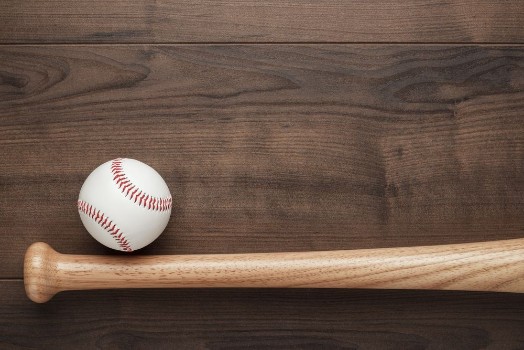 Picture of Closeup of baseball bat and ball on wooden table with copy space