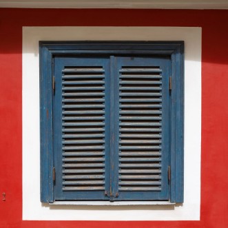 Image de A beautiful old window on a red wall with closed blue shutters The window is photographed in the old town in Riga