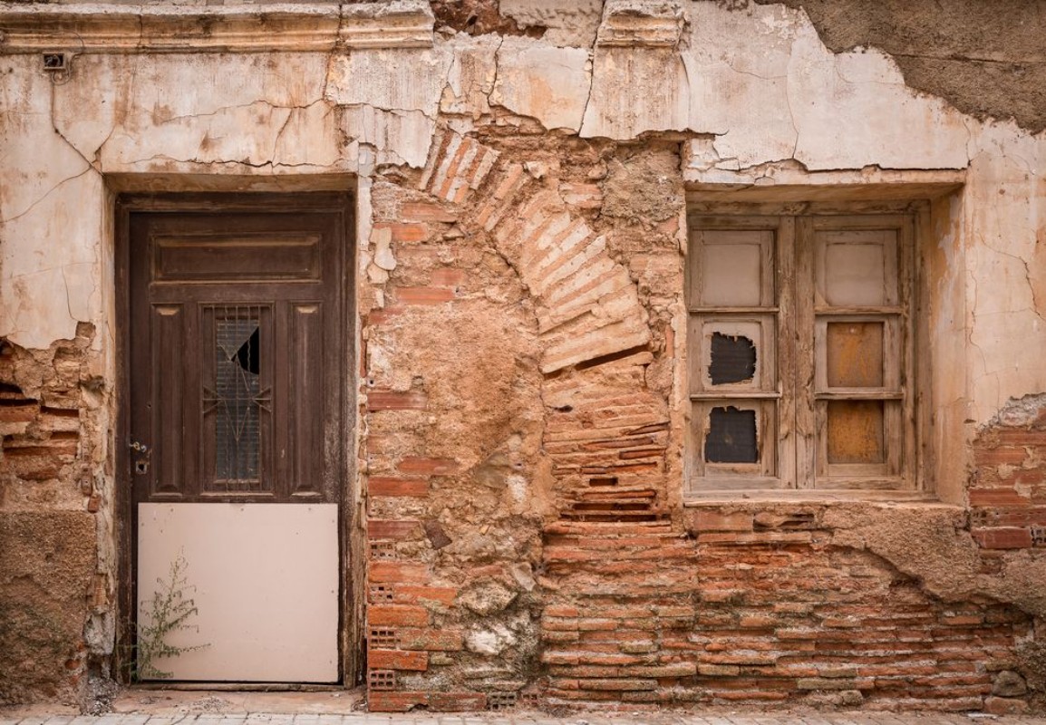 Afbeeldingen van Ancient wooden door and a window on a wall made of bricks