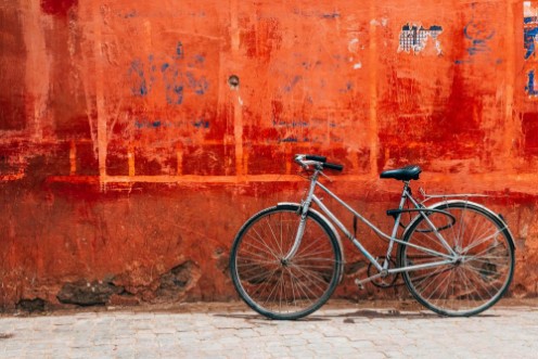 Bild på Old bike standing at colorful red wall