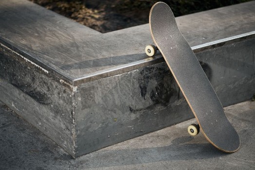 Bild på Black skateboard in concrete skatepark